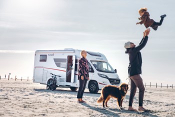 Familie met hond bij de camper